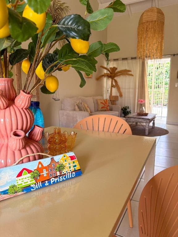 Eettafel met decoratieve vaas en citroentak, woonkamer met bank op de achtergrond