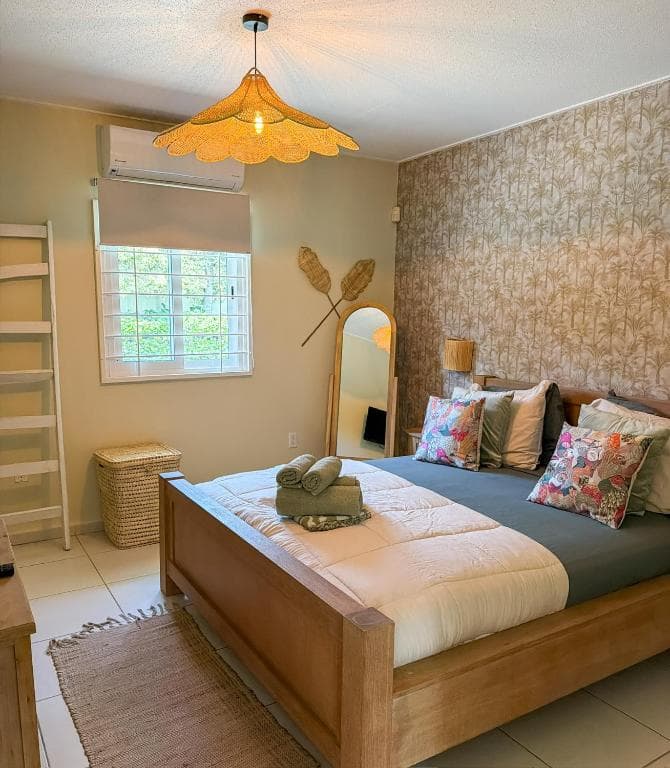 Slaapkamer met kingsize bed, gevlochten hoofdeinde-accenten en airconditioning