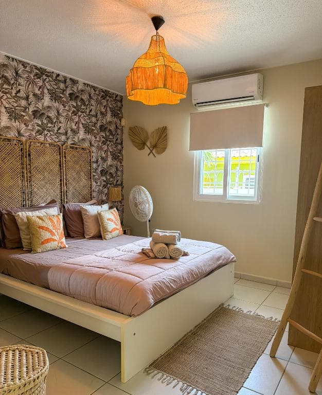 Tweede slaapkamer met kingsize bed, rieten roomdivider en ventilator