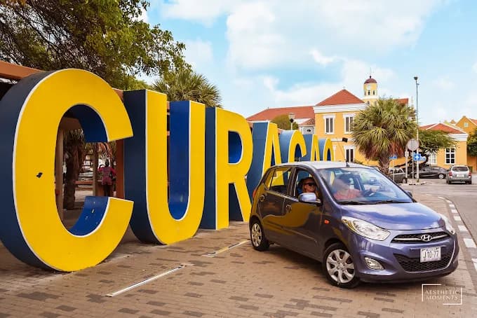 Rental car next to the colorful CURAÇAO sign in Willemstad